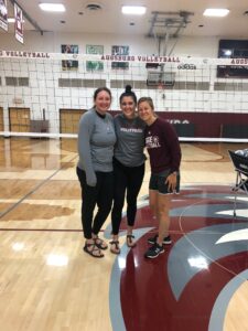 Jaelyn Arndt on the volleyball court with two others at Augsburg. 